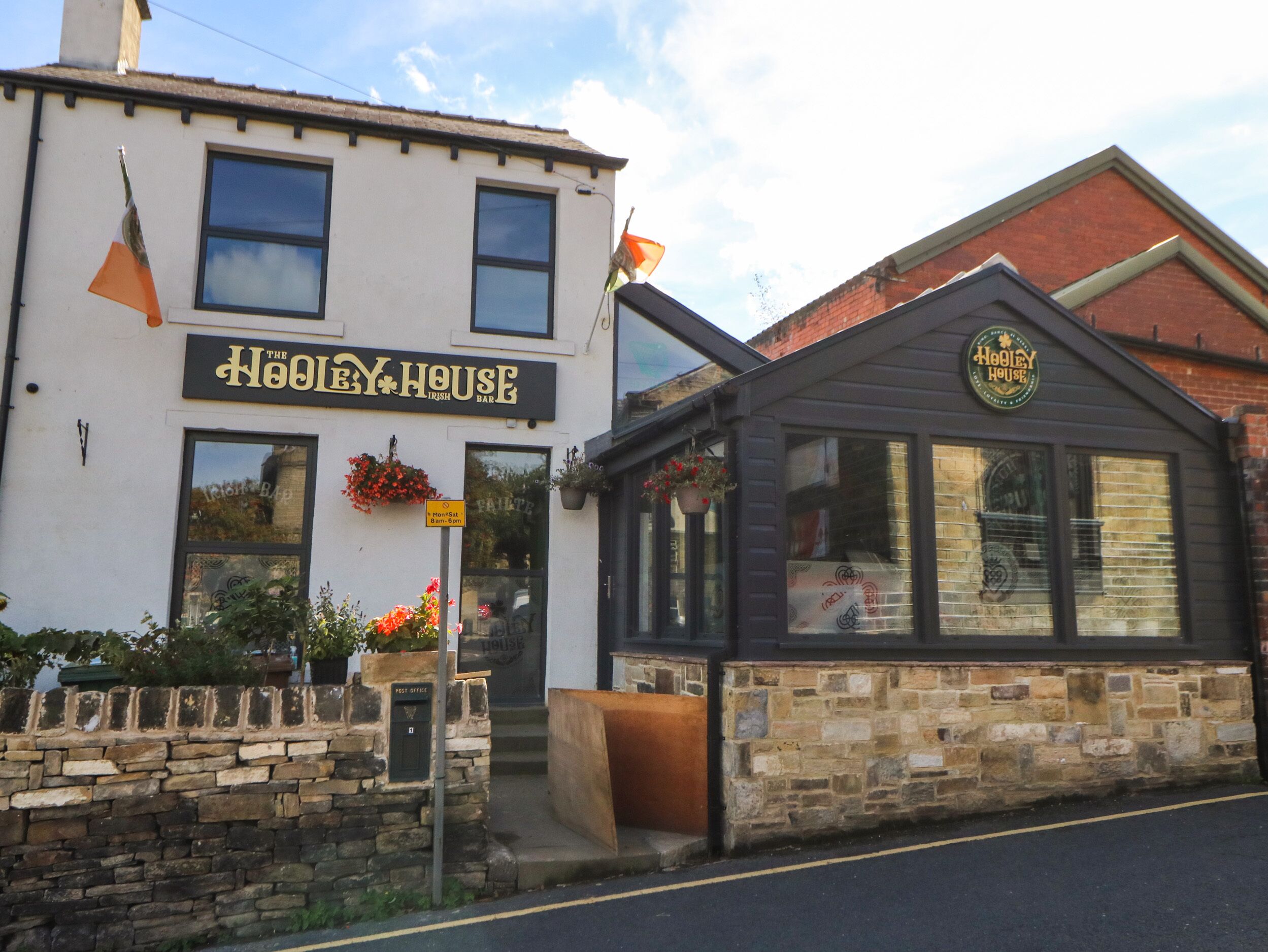 A building with a sign reading "The Hooley House Irish Bar".