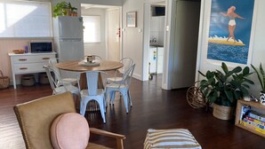 Eine moderne Küche mit Kühlschrank, Mikrowelle und Essbereich mit Stühlen und Tisch.