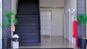 A hotel entrance with a staircase, a reception desk, and a row of lockers. - VR2 Hotel (Lencois Paulista)