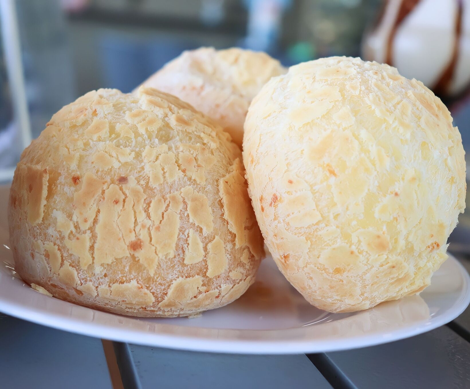Three round, pale yellow pastries on a white plate.