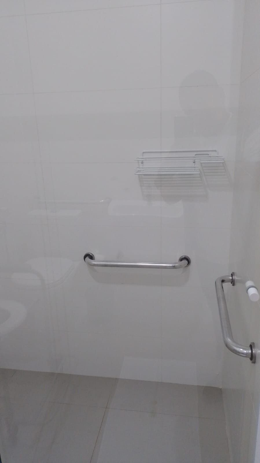 Une salle de bain équipée d’une barre d’appui, d’un porte-serviettes et d’une barre de maintien.