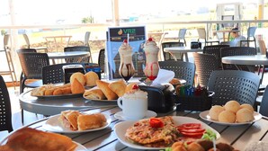 A table with various food items including pastries, a pizza, and a dessert. - VR2 Hotel (Lencois Paulista)