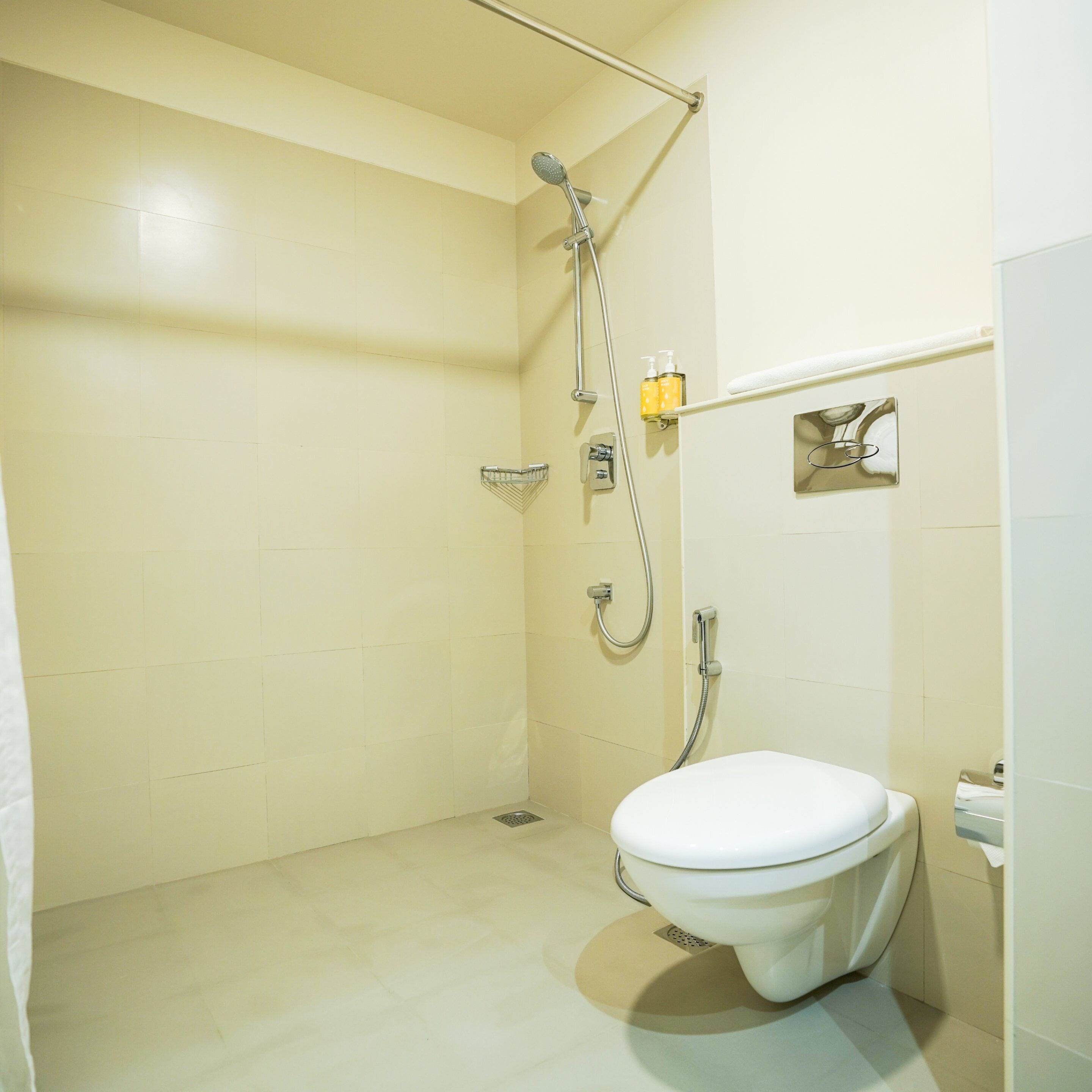 Un baño pequeño y limpio con inodoro, ducha y toallero.