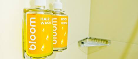Dos botellas de jabón para cabello y cuerpo sobre una repisa en el baño.