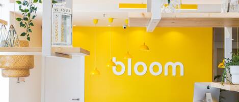 A modern interior with a yellow wall displaying the word "bloom".