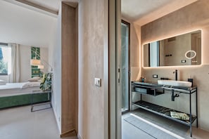 Un bagno moderno con uno specchio grande, un lavandino e una zona doccia.