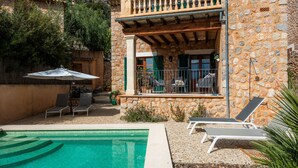 A stone building with a balcony, a swimming pool, and outdoor seating. - Holiday Home 'Can Bordoy' with Mountain View, Pool, Garden & Terrace (FORNALUTX)