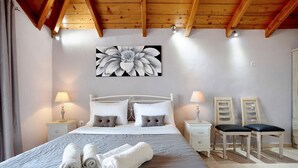 Una camera da letto con un letto, due comodini, un quadro e una sedia.