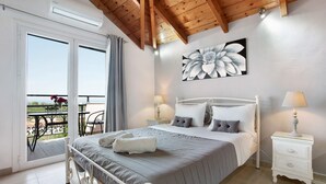 Una camera da letto con un letto, comodini, un quadro e un balcone.