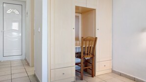Una habitación con un armario, una silla y una puerta.
