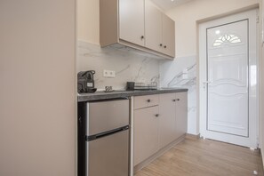 Une cuisine avec un dosseret en marbre, des appareils en acier inoxydable et des meubles de couleur beige.