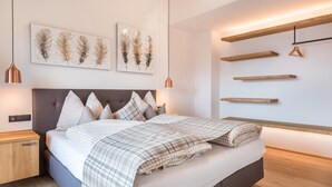 Une chambre à coucher moderne avec un lit, une tête de lit, des œuvres d’art murales, des luminaires suspendus et des étagères intégrées.