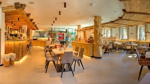 Un restaurant avec un décor intérieur en bois, un bar et des tables à manger avec des chaises.