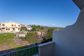 Zona residencial amb una casa, un balcó amb barana i un cel serè.