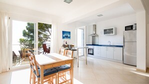 Une cuisine moderne avec des armoires blanches, une hotte de cuisinière en acier inoxydable et un four à micro-ondes.