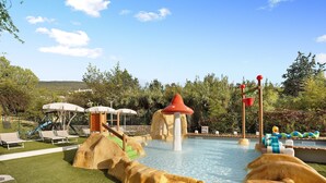 A pool area with slides, a water play structure, and lounge chairs. - "Mobile Home Next 229" with Pool, Garden & Wi-Fi (Pietra Ligure)