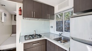 A compact kitchen with a gas stove, a sink, and a refrigerator. - "Mobile Home Next 229" with Pool, Garden & Wi-Fi (Pietra Ligure)
