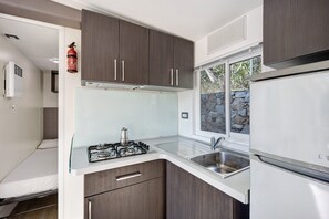 A compact kitchen with a gas stove, a sink, and a refrigerator.