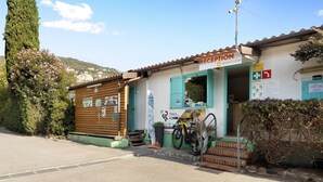 A reception building with a sign, a bicycle, and a mountain view in the background. - "Mobile Home Next 229" with Pool, Garden & Wi-Fi (Pietra Ligure)