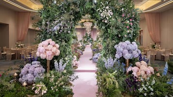Un arc floral que dona pas a una sala de banquet amb taules preparades per dinar.