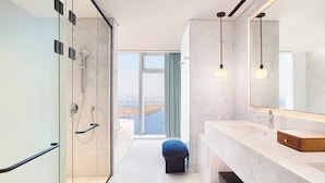 A modern bathroom with a shower, a large mirror, and a view of a river. - Hotel Naru Seoul - MGallery Collection (Seoul)