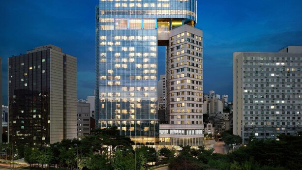 A modern hotel with a glass facade, multiple floors, and a prominent signage. - Hotel Naru Seoul - MGallery Collection (Seoul)
