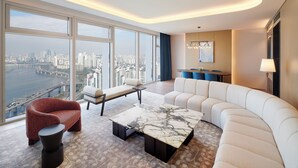 A modern living room with a curved sofa, a red armchair, and a marble coffee table. - Hotel Naru Seoul - MGallery Collection (Seoul)