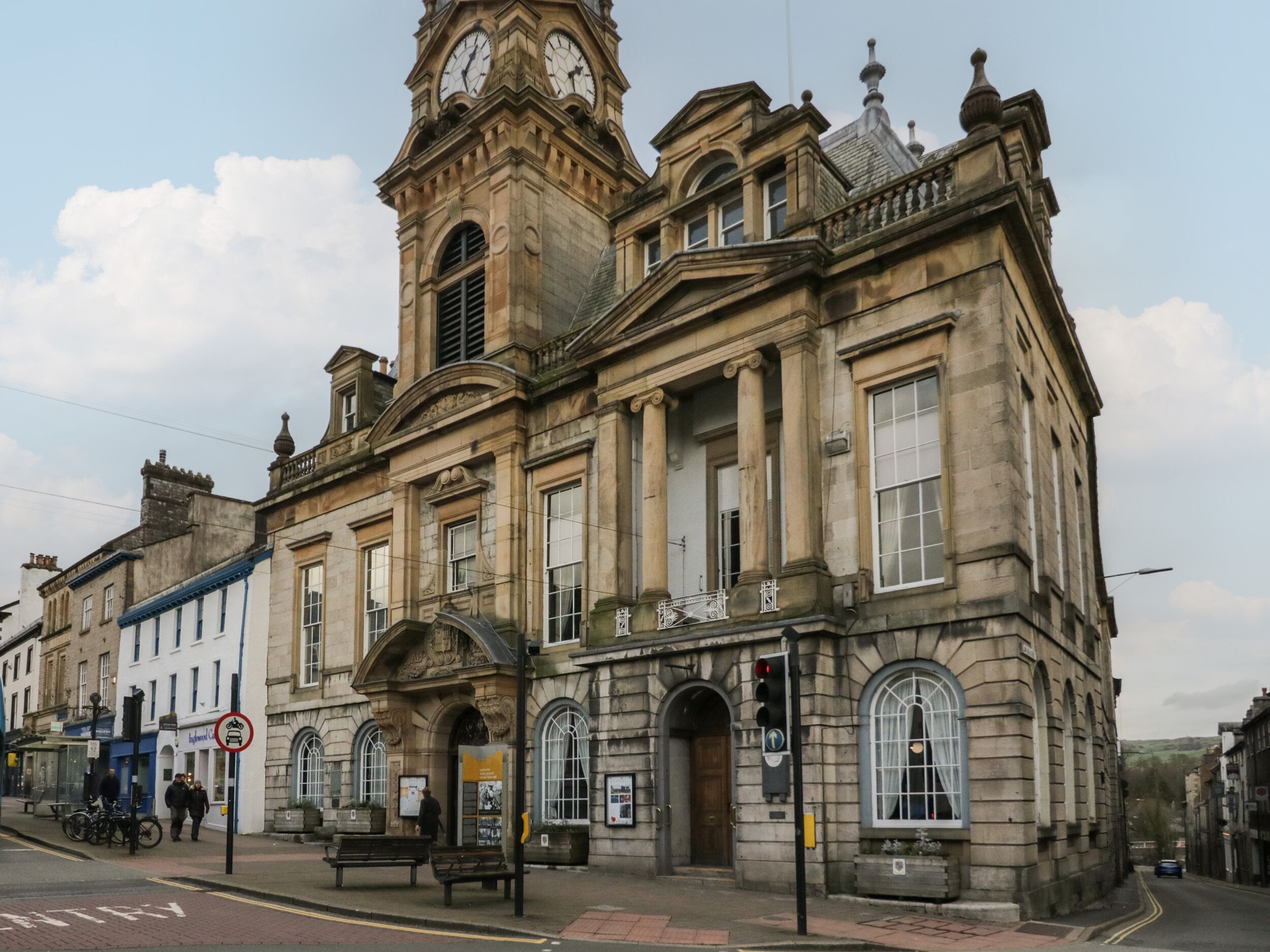 A historic building with a clock tower, large windows, and a prominent entrance.