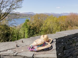Un mur de pierres sur lequel sont posés un chapeau de paille et des lunettes de soleil.