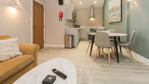 Un salon moderne comprenant un canapé, une table basse et un coin repas avec des chaises et une table.