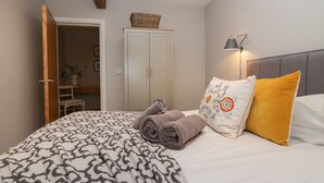 Une chambre à coucher avec un lit, une armoire, une lampe et un panier accroché au mur.
