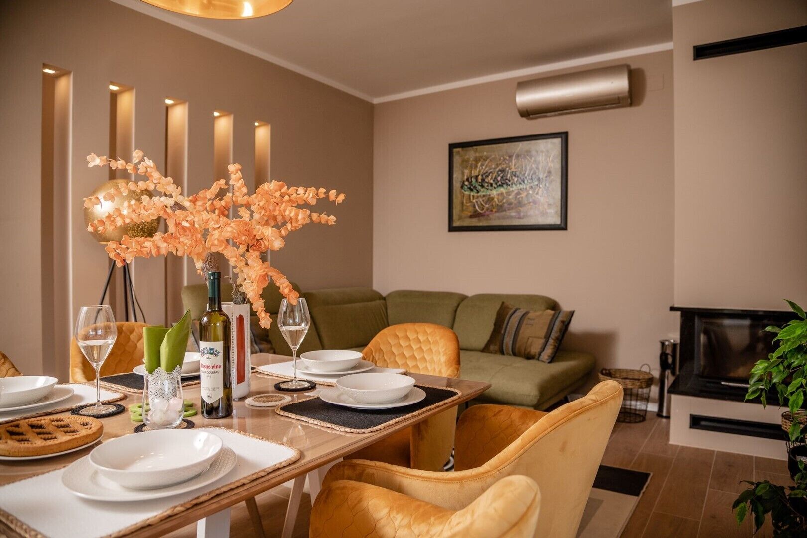 A dining area with a table set for four, a sofa, and a fireplace.