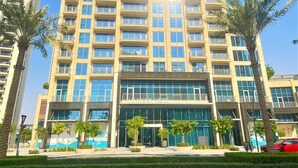 A multi-story residential building with balconies, large windows, and a central entrance. - Luxury Dubai Creek Harbour Waterfront Apartment (Dubai)