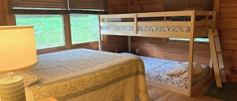 Una cama litera con un edredón estampado, una lámpara de noche y una decoración de estrella en la pared.