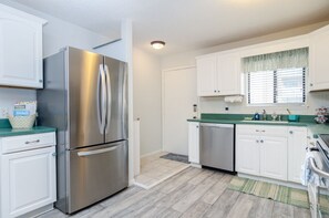 Enjoy cooking in this well-equipped kitchen with a refrigerator, dishwasher, and ample counter space.
