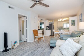 Un salon moderne doté d’un ventilateur de plafond, d’un coin repas et d’une cuisine.