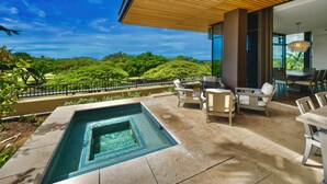 Un espace piscine extérieur moderne offrant une vue sur une végétation luxuriante et des collines.