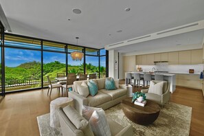 Enjoy a panoramic view of lush greenery from the spacious living area with a comfortable seating arrangement and dining space.