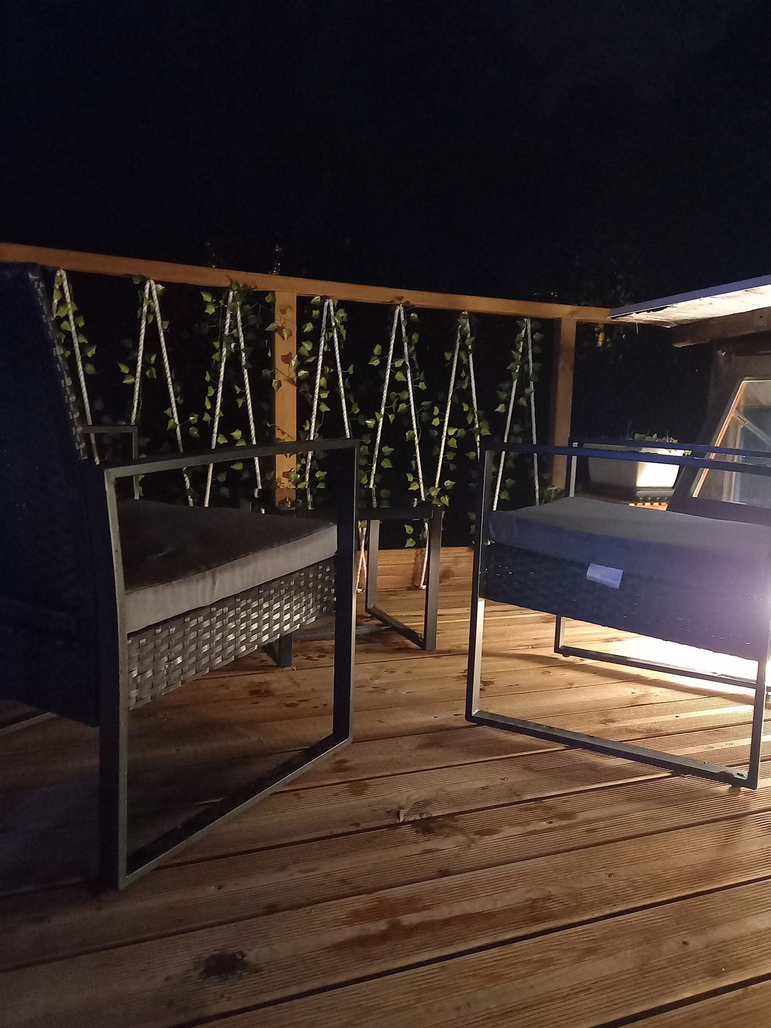 Un pontile di legno con due altalene in metallo e una panchina.