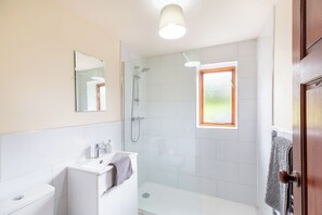 A bathroom with a shower, sink, and toilet. - Owlbury Hall Barn (Montgomery)