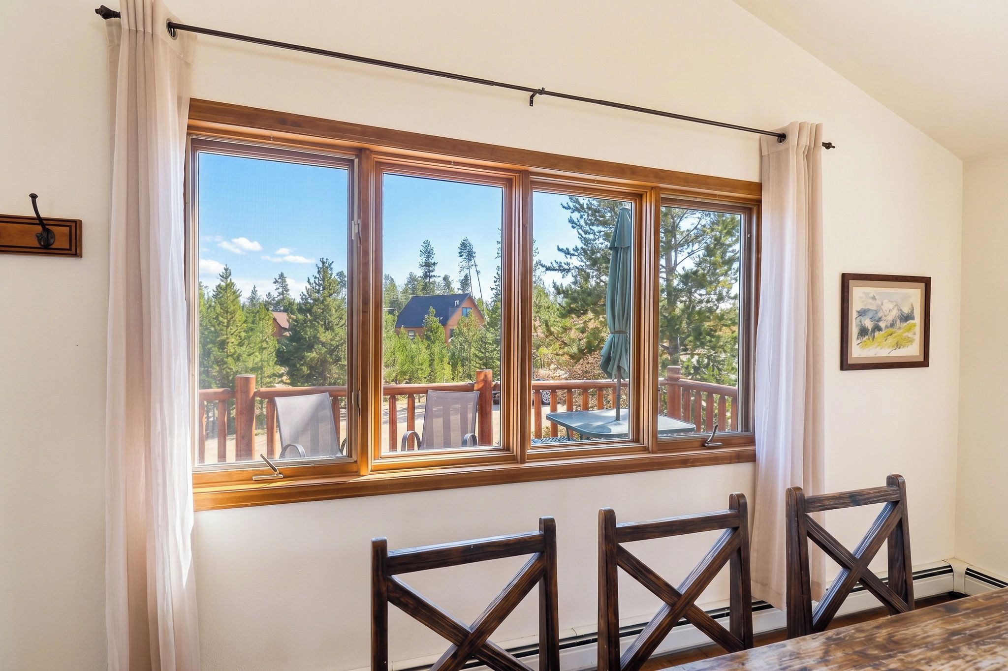 A room with a large window overlooking a deck and trees.