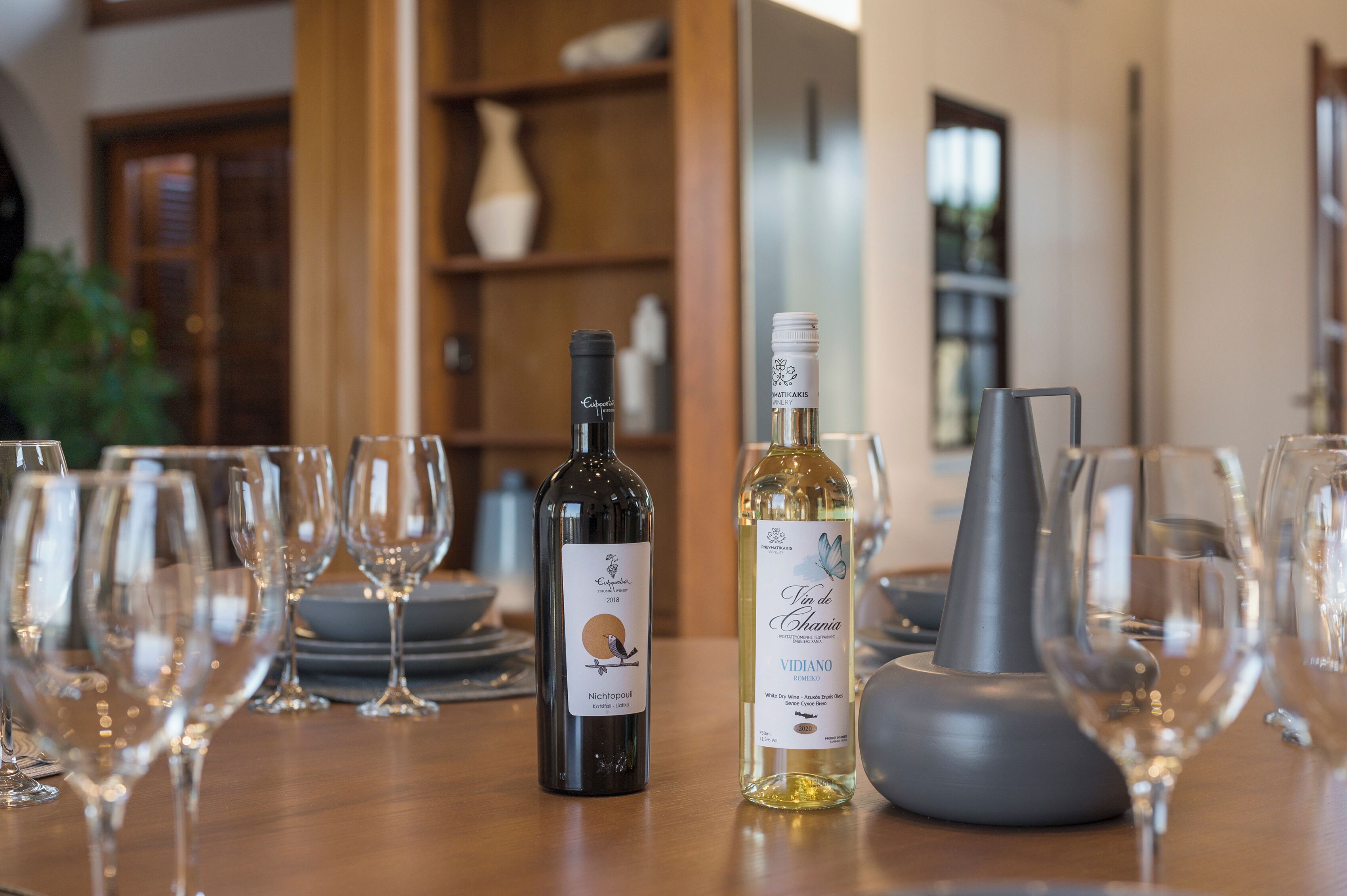 A table with wine bottles and glasses, indicating a wine tasting event.
