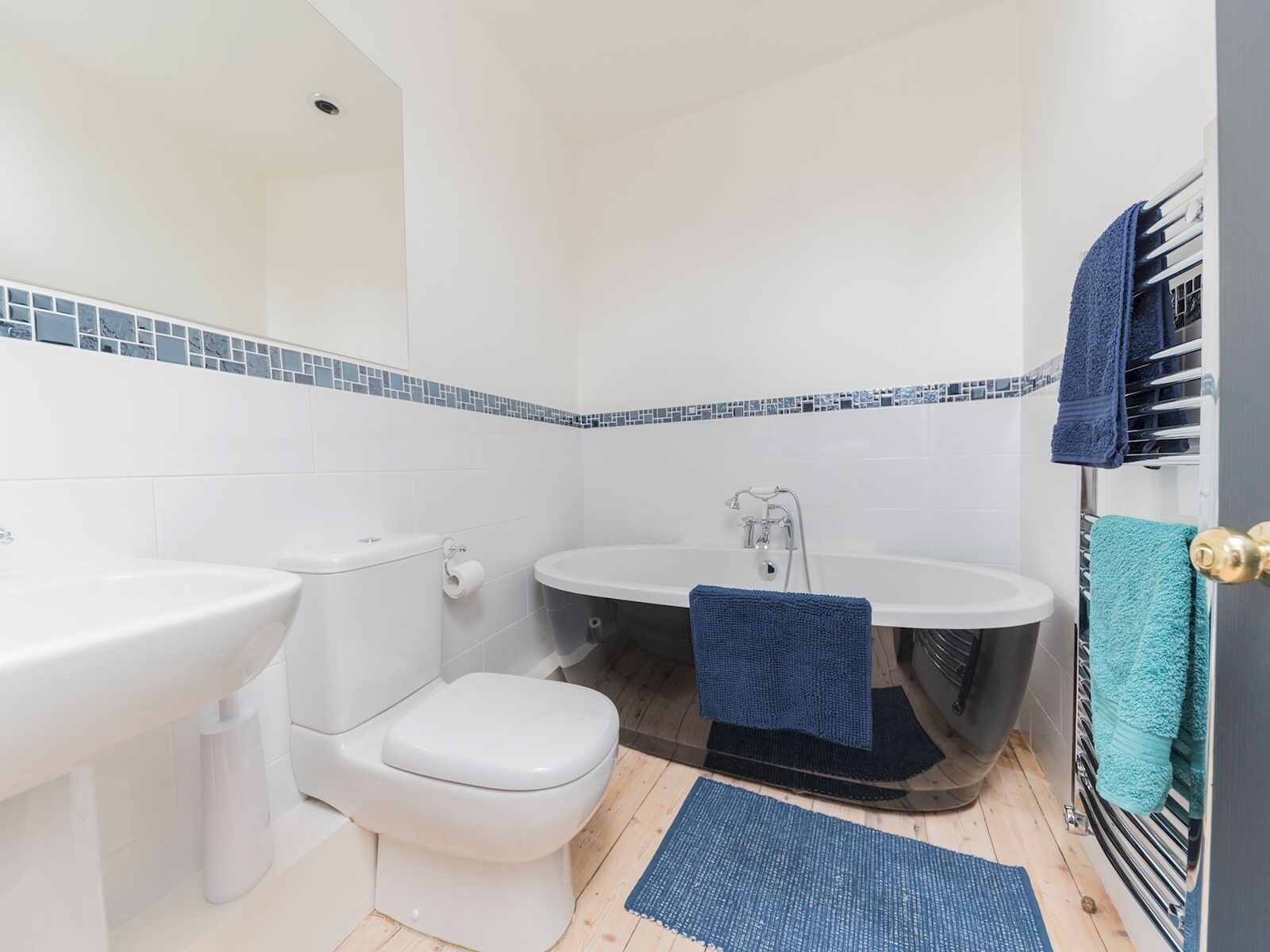 A bathroom with a toilet, sink, and bathtub.