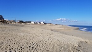 A sandy beach with a few buildings in the background. - Comfortable and clean beach cottage convenient access to the beach. (Kitty Hawk)
