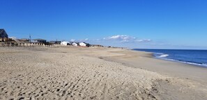 Ranta lähistöllä, aurinkotuoleja, rantapyyhkeitä