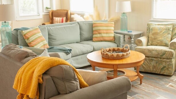 A living room with a sofa, armchair, and a round coffee table. - Comfortable and clean beach cottage convenient access to the beach. (Kitty Hawk)
