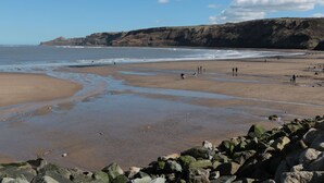 A beach with rocky outcrops and a clear sky. - Pond Farm View (Saltburn-by-the-Sea)