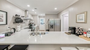 A modern kitchen with a white countertop, stainless steel appliances, and a coffee station. - Relaxing Home close the Battery/Mins to Everything (Smyrna)