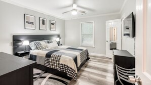 A bedroom with a bed, bedside tables, a desk, a ceiling fan, and a TV. - Relaxing Home close the Battery/Mins to Everything (Smyrna)