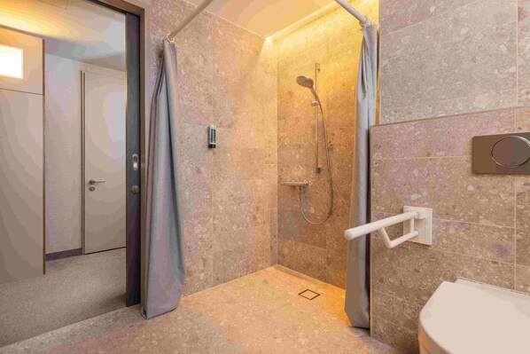 A modern bathroom with a shower, toilet, and a towel rack. - Hey Lou Hotel Monheim am Rhein (Monheim)